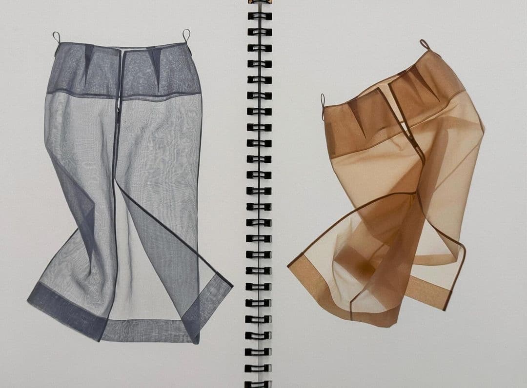 A spiral sketchbook spread with two sheer organza skirt studies